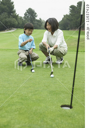 Mother teaching son to play golf Mother teaching son to play golf 11637419