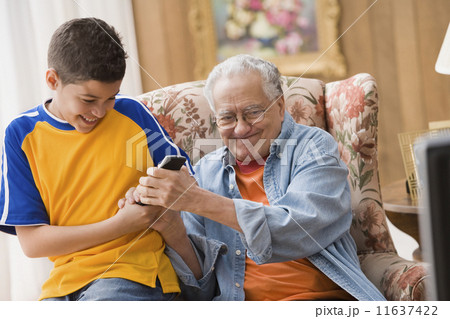 Young boy and his grandfather fighting over the remote control Young boy and his grandfather fighting over the remote control 11637422