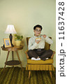 Nerdy Asian man eating in chair 11637428