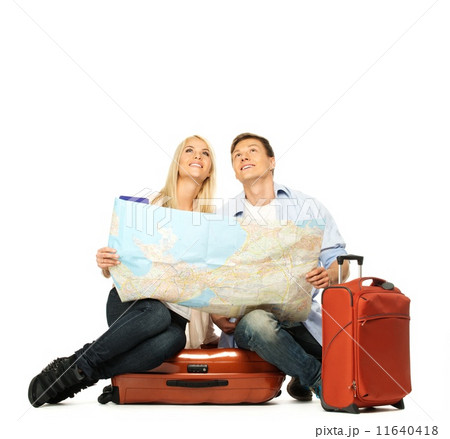 Smiling beautiful young couple with a map sitting on a suitcase Smiling beautiful young couple with a map sitting on a suitcase 11640418