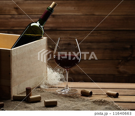 Bottle and glass of red wine on a wooden table Bottle and glass of red wine on a wooden table 11640663