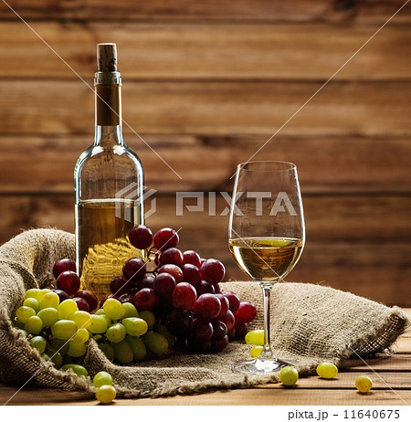 Bottle of red white, glass and grape on a sack in wooden interior Bottle of red white, glass and grape on a sack in wooden interior 11640675