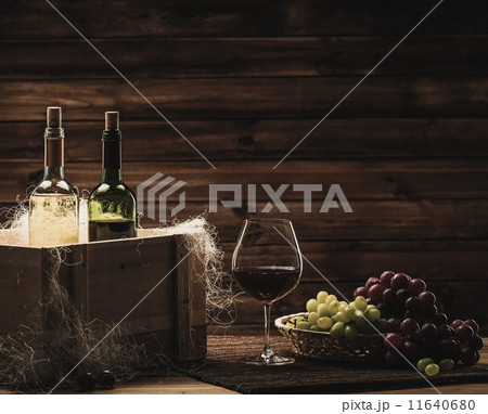 Bottles of red and white wine, glass and grape on a wooden interior Bottles of red and white wine, glass and grape on a wooden interior 11640680