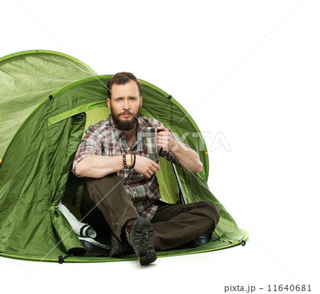 Handsome traveler in a tent with coffee cup Handsome traveler in a tent with coffee cup 11640681