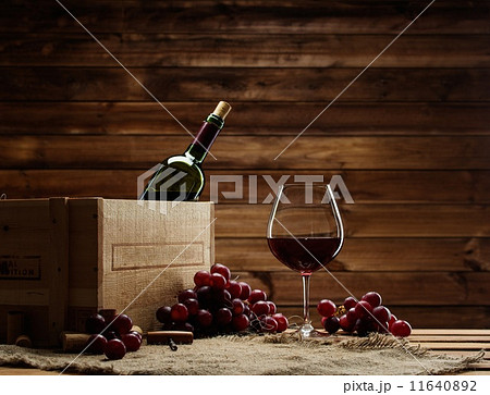 Bottle, glass and red grape on a wooden table Bottle, glass and red grape on a wooden table 11640892