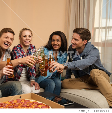 Group of young friends with pizza and bottles of drink celebrating in home interior 11640911