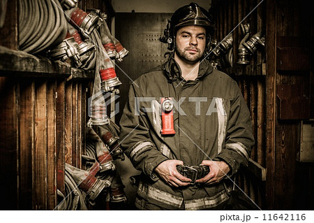 Firefighter in storage room with fire hoses 11642116