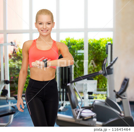 smiling woman with heart rate monitor on hand 11645464