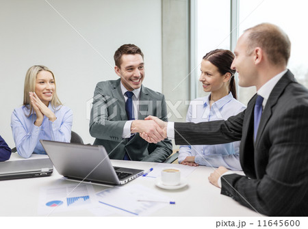 two businessman shaking hands in office 11645600