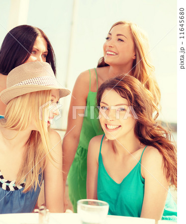 group of smiling girls in cafe on the beach group of smiling girls in cafe on the beach 11645680
