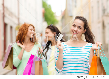 smiling teenage girls with shopping bags on street smiling teenage girls with shopping bags on street 11645730