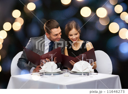 smiling couple with menus at restaurant smiling couple with menus at restaurant 11646273