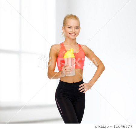 smiling sporty woman with protein shake bottle 11646577