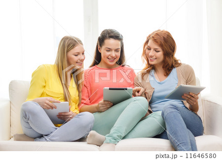 three smiling teenage girls with tablet pc at home 11646580