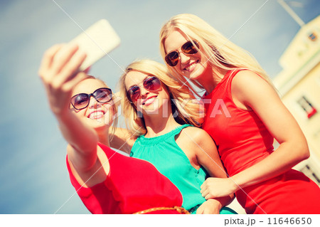 smiling girls taking photo with smartphone camera 11646650