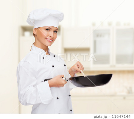 smiling female chef with pan and spoon 11647144