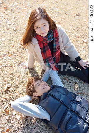 秋の公園で寄り添う若いカップル 11663122
