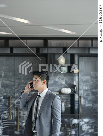 Young Asian business man talking with mobile phone Young Asian business man talking with mobile phone 11665337