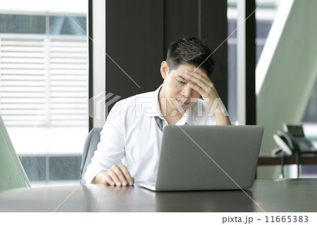 Young Asian businessman upset in front of laptop Young Asian businessman upset in front of laptop 11665383