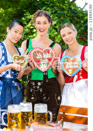 Women in traditional Bavarian clothes in beergarden 11669190