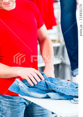 Man buying blue jeans in shop Man buying blue jeans in shop 11669270
