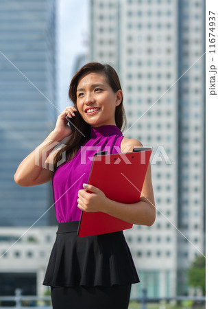 A young confident beautiful Financial Advsior connecting with her client on the mobile device/ phone A young confident beautiful Financial Advsior connecting with her client on the mobile device/ phone 11674937