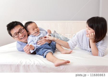 happy family playing on white bed happy family playing on white bed 11680863