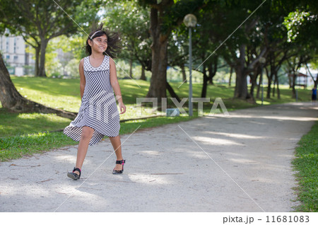 Happy Young asian girl walking and hopping in the park Happy Young asian girl walking and hopping in the park 11681083