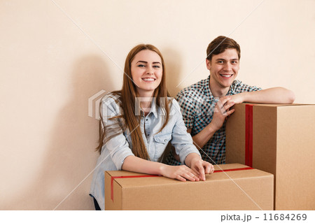 Smiling couple leaning on boxes Smiling couple leaning on boxes 11684269