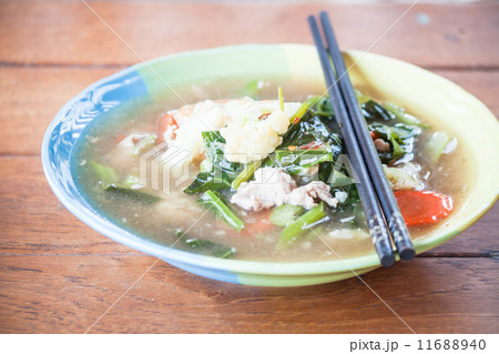 Fried rice noodles topped with pork and wood chopsticks 11688940