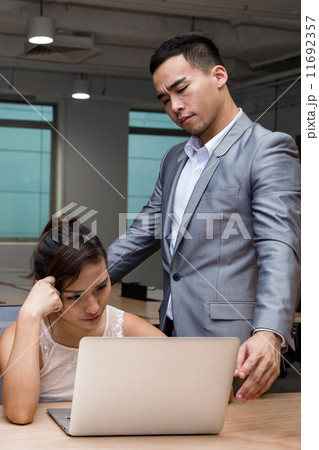 Young Asian business associates solving work problems together 11692357