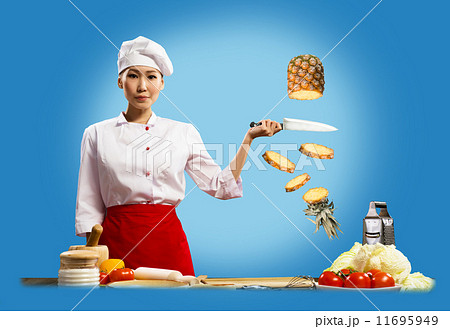 Asian female chef cuts pineapple 11695949