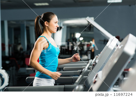 attractive young woman runs on a treadmill attractive young woman runs on a treadmill 11697224