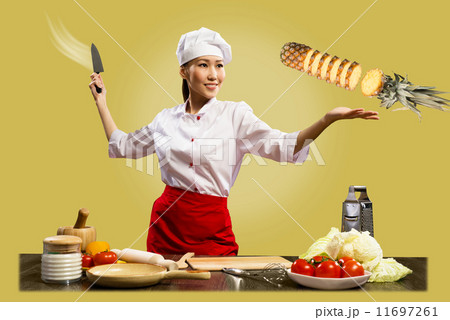 Asian female chef cuts pineapple 11697261