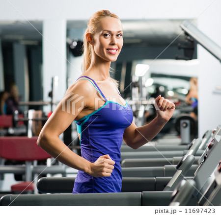 attractive young woman runs on a treadmill 11697423