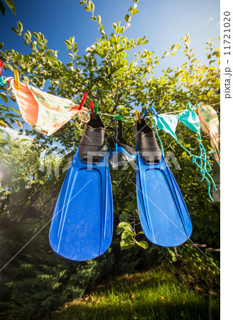 flippers and snorkeling mask drying on clothesline flippers and snorkeling mask drying on clothesline 11721020