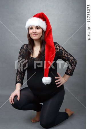 beautiful pregnant santa woman tenderly holding her tummy 11738078