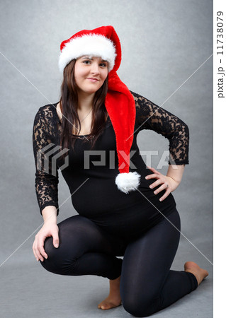 beautiful pregnant santa woman tenderly holding her tummy 11738079