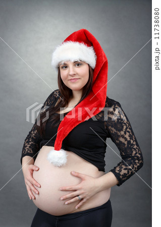 beautiful pregnant santa woman tenderly holding her tummy 11738080