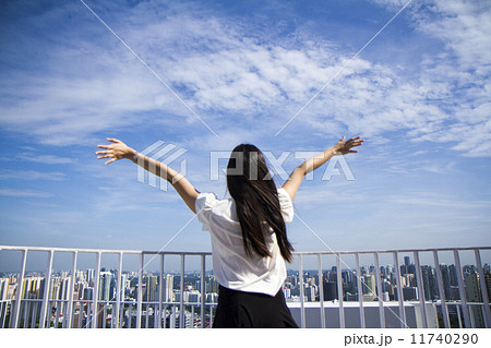 Young woman arms raised enjoying the fresh air 11740290