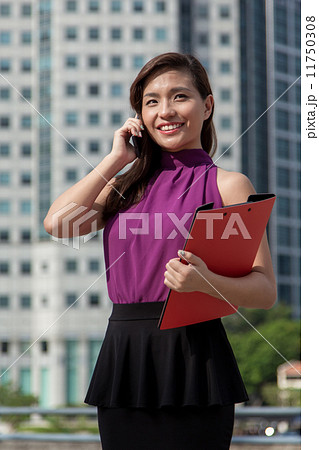 Young Asian businesswoman using cellphone outdoor 11750308