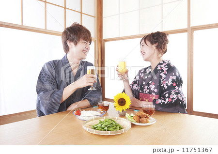 和室でビールを乾杯する浴衣の男女 11751367