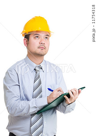 Engineer writing somthing on clipboard and looking up Engineer writing somthing on clipboard and looking up 11754318