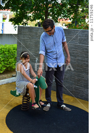 Asian indian bother accompanying his young sister at the playground Asian indian bother accompanying his young sister at the playground 11759246