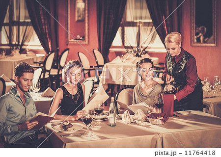 Group of young friends with menus choosing in a luxury restaurant 11764418