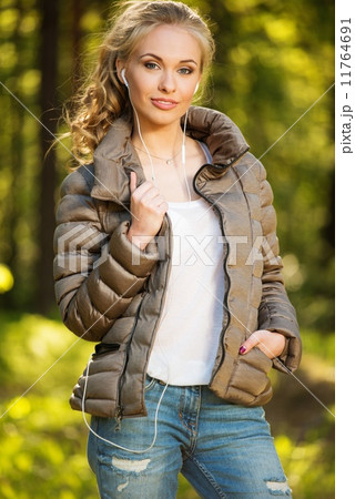 Beautiful teenage girl listens music outdoors Beautiful teenage girl listens music outdoors 11764691