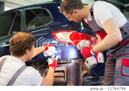 Two workers with colour samples choosing correct shade in a car body workshop 11764788