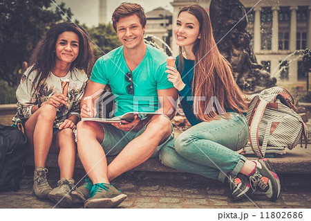 Group of multi ethnic students with ice-cream near fountain in a city park 11802686