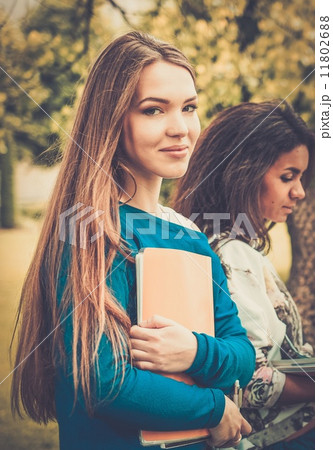 Multi ethnic girls students in a city park 11802688