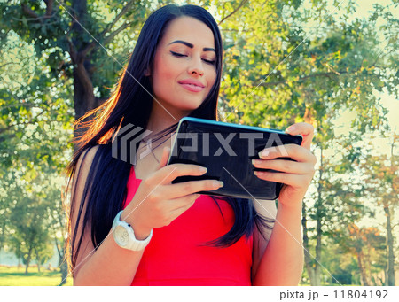 Toned Image Beautiful Young Woman Tablet Computer. Female student using her tablet-pc outdoors. Toned Image Beautiful Young Woman Tablet Computer. Female student using her tablet-pc outdoors. 11804192